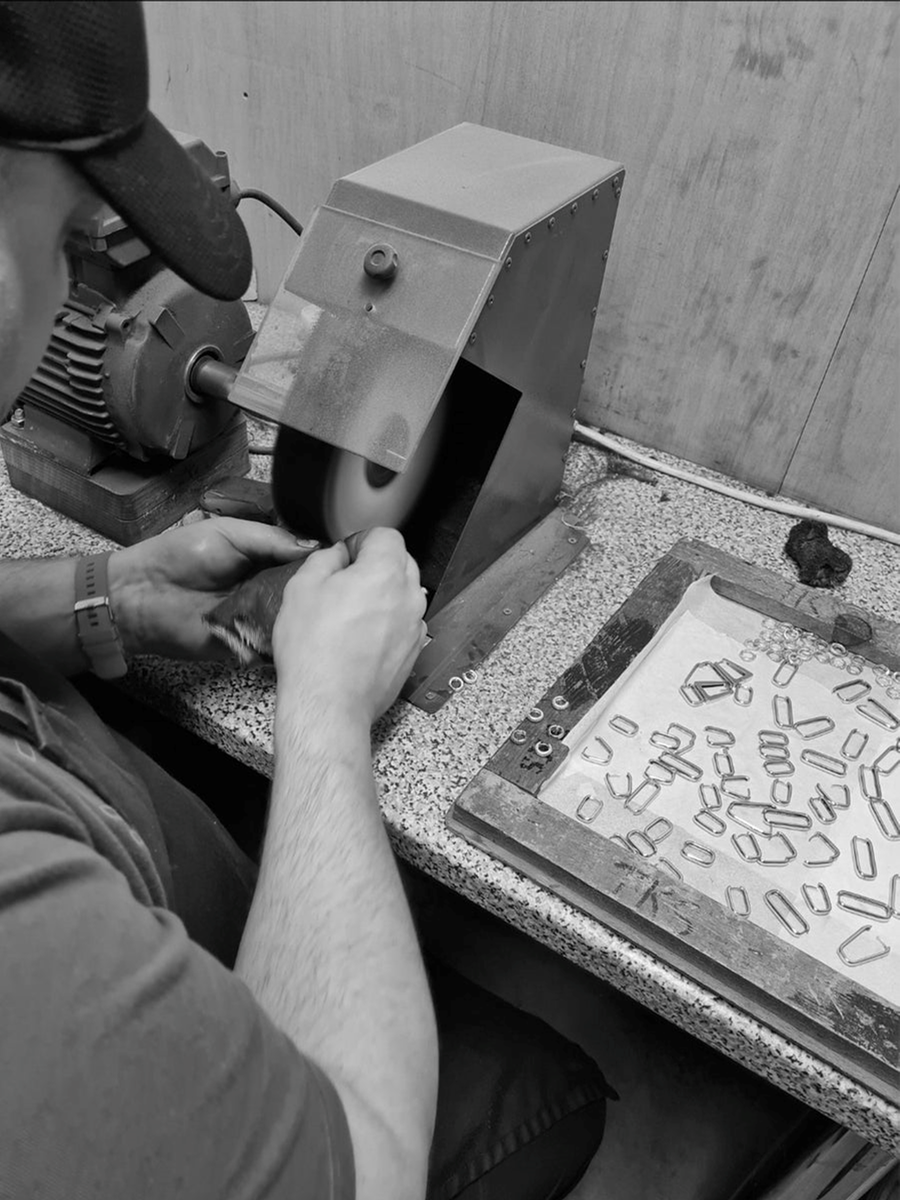 Man applying a gold plating to handmade wedding rings in a workshop