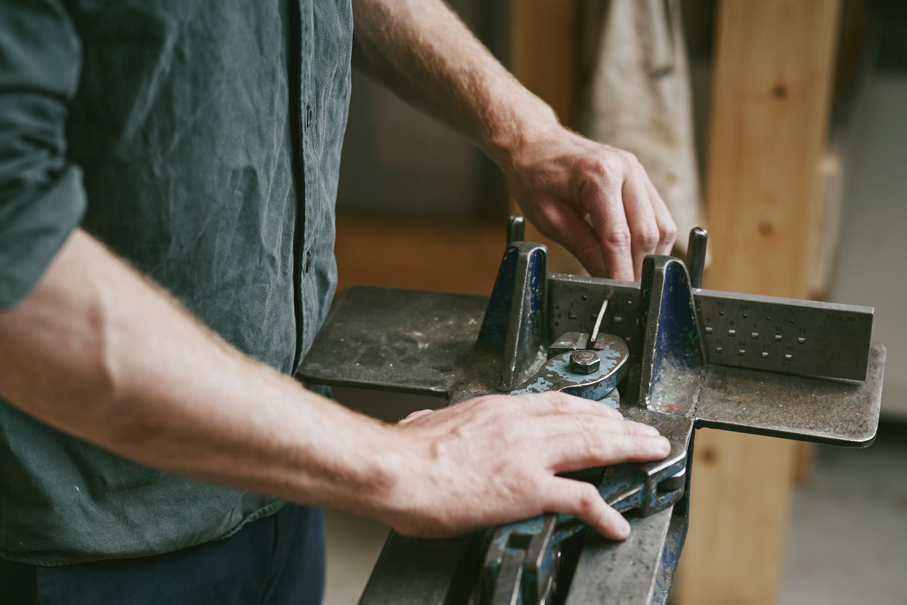 Independent jeweller working metal at his workbench