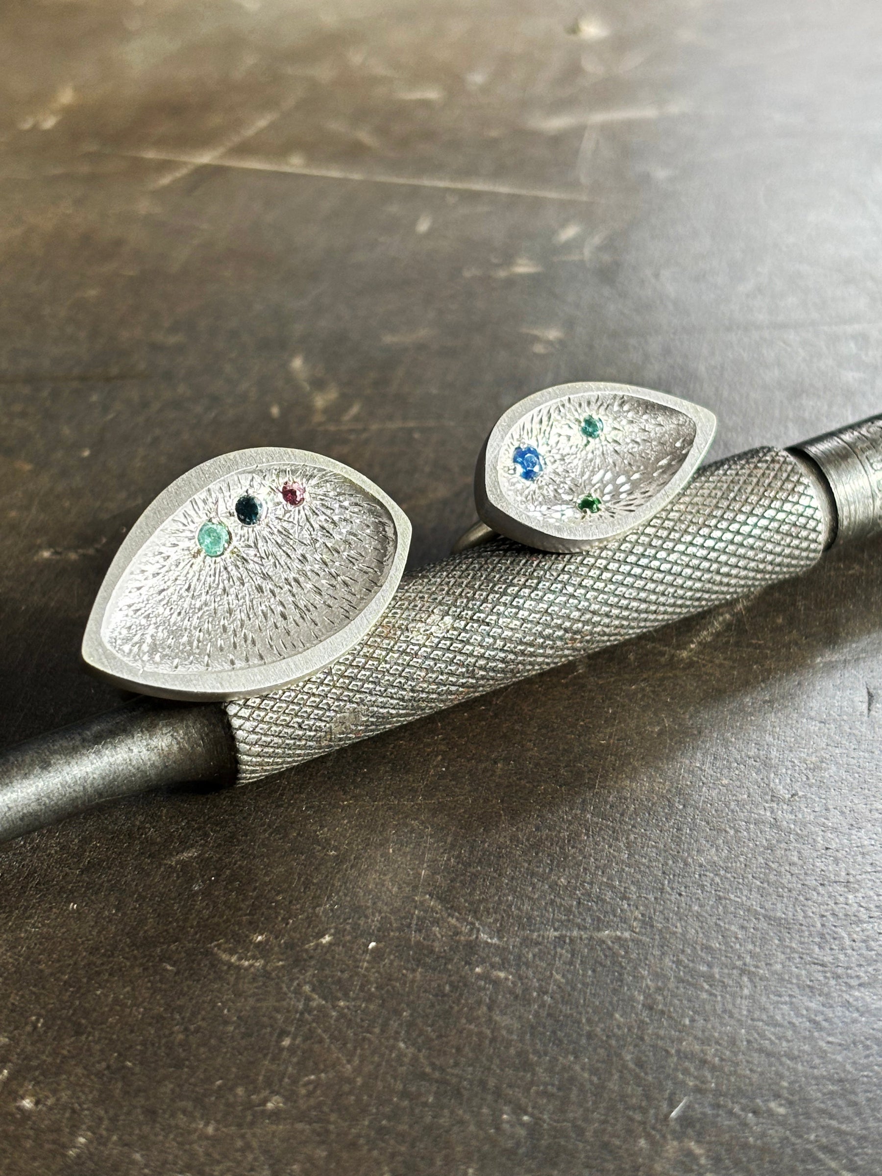 Sterling silver textured ring with coloured precious stones on a steel tool