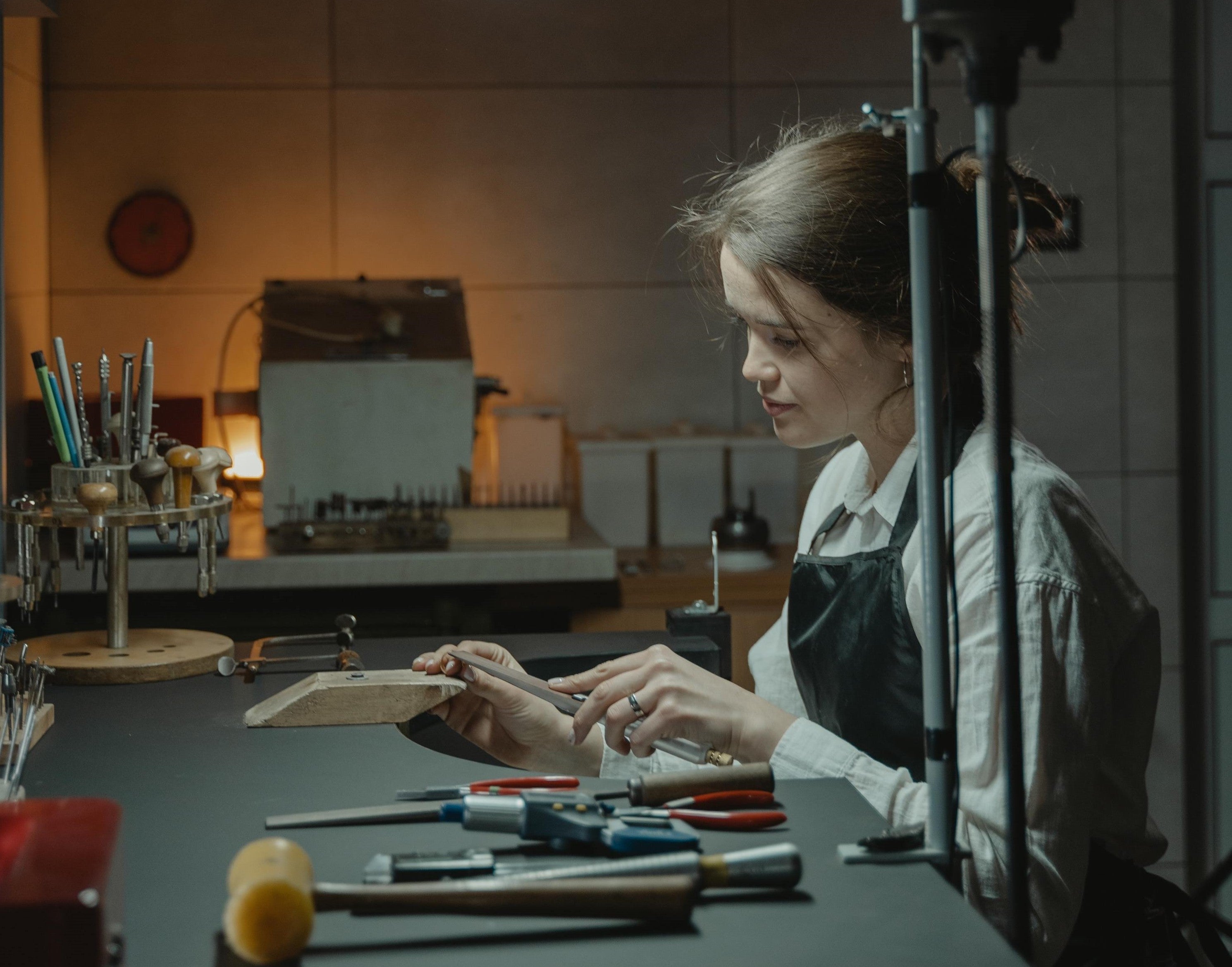 Independent jeweller at her workbench, making a bespoke engagement ring