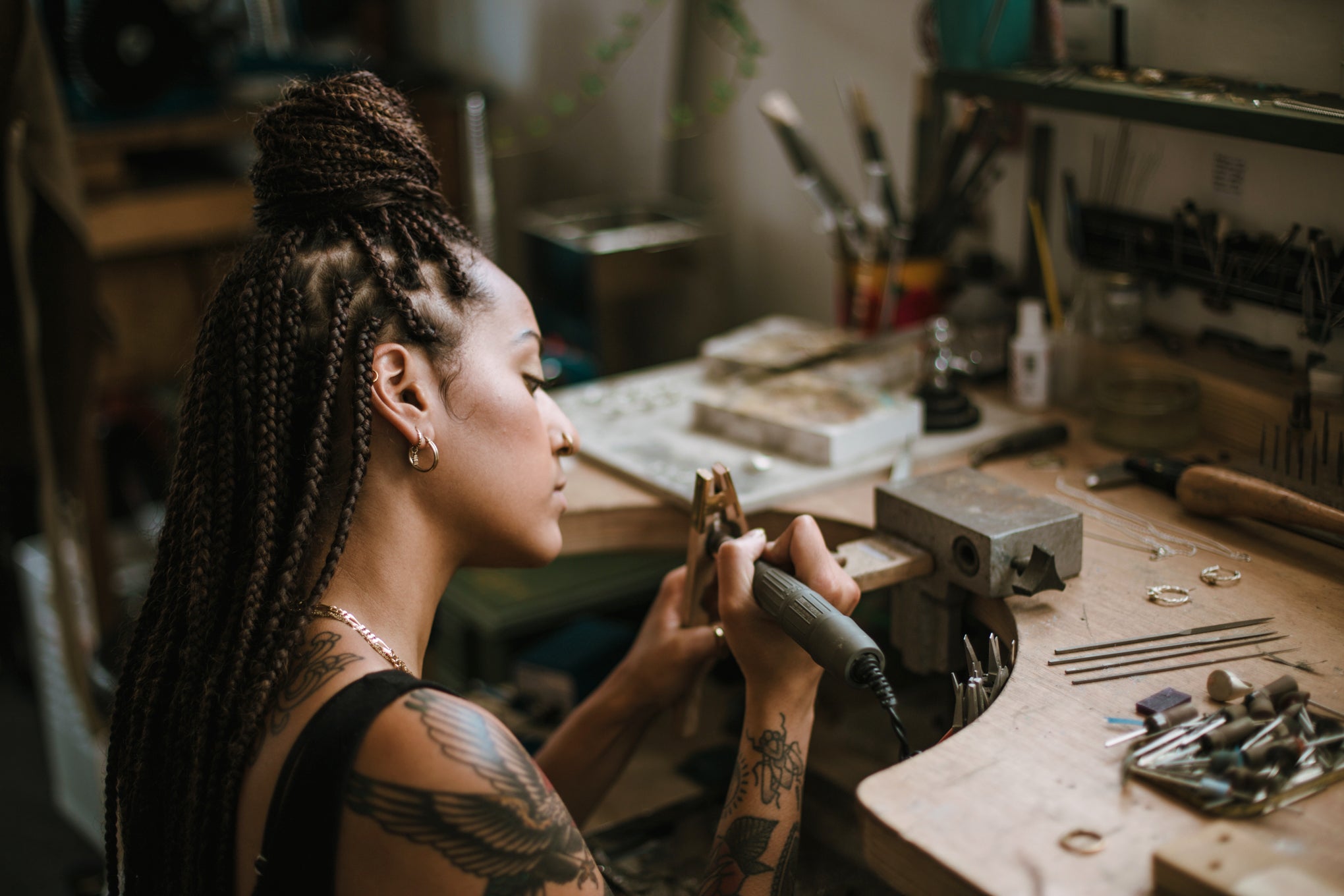 Independent jeweller polishing a bespoke engagement ring at her workbench