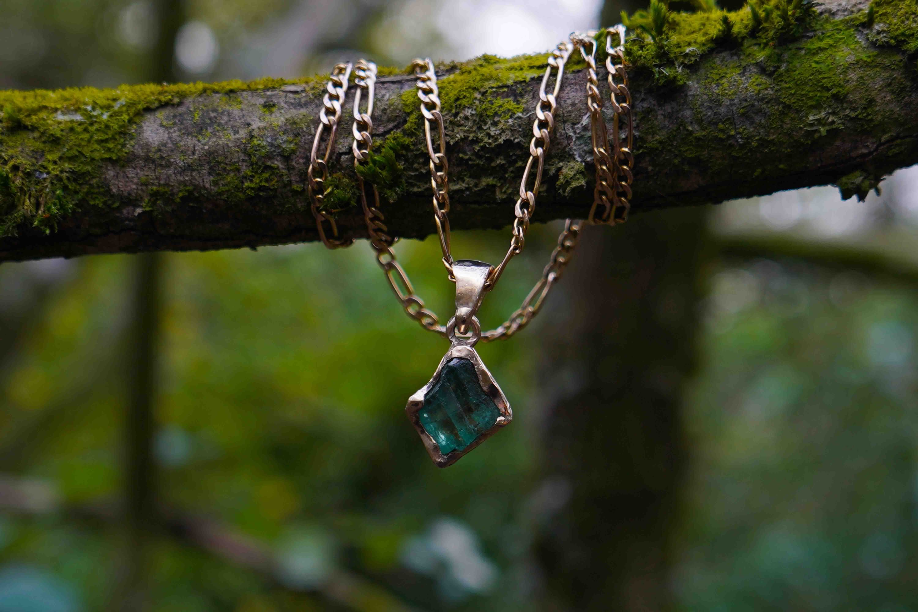 Bespoke necklace by Luke Brient, dangling from a branch
