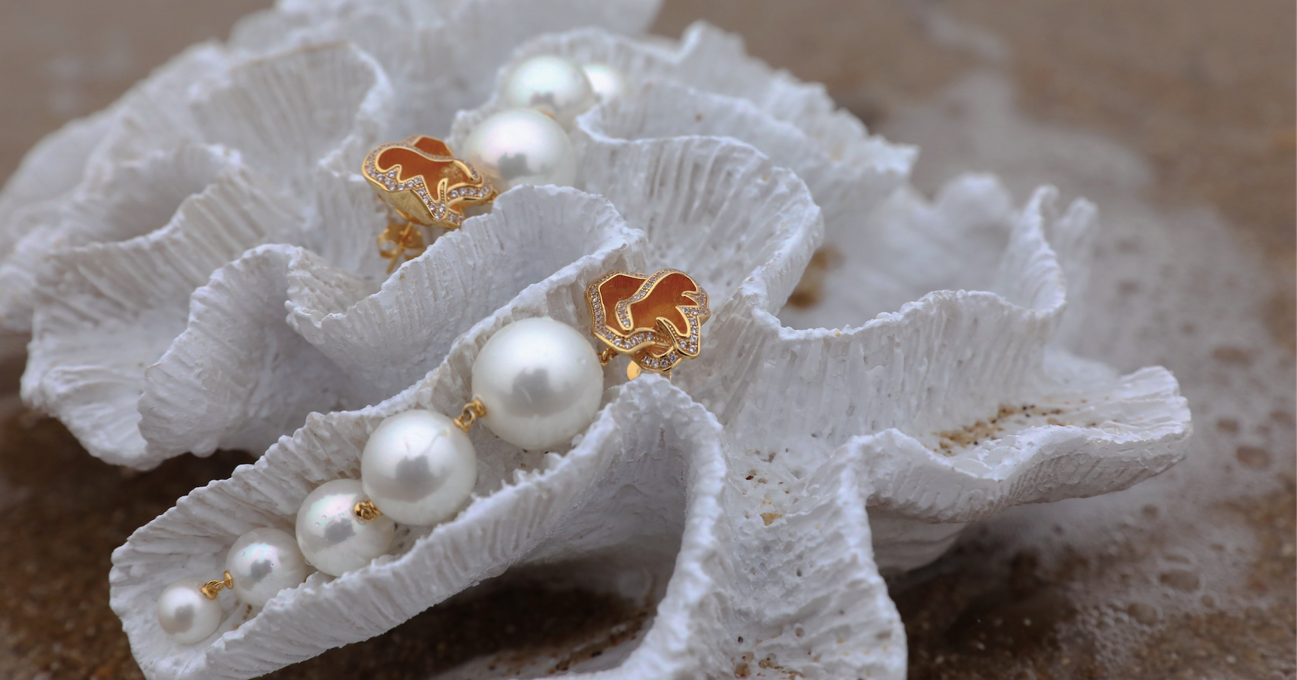 Pair of bespoke pearl bridal earrings resting in a sea shell, made by Georgia Wang