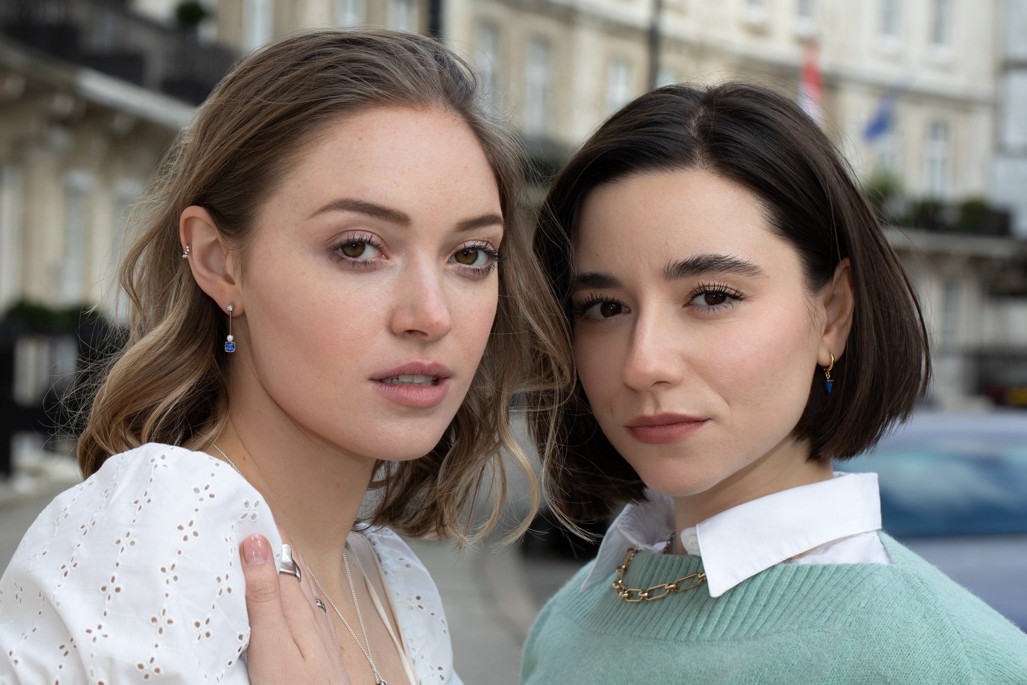 Two white models standing in a street, wearing bespoke bridal jewellery